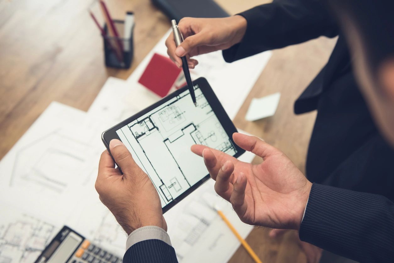 Two people are holding a tablet and pen